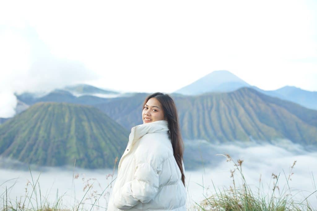 Peserta paket wisata Bromo berfoto dengan latar Gunung Batok dan Gunung Semeru